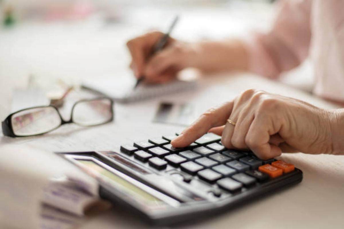 Concetto di calcolo della pensione, anziani che contano le finanze su una calcolatrice domestica